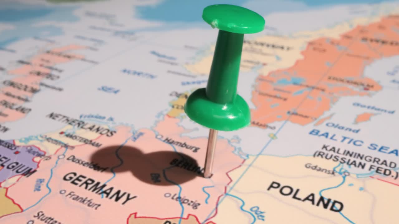 германия - концепция путешествия с зеленым штифтом на карте мира. точка расположения на карте указывает на берлин, столицу германии.