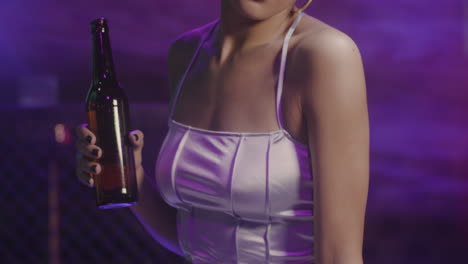 attractive girl drinking beer and dancing at disco 1