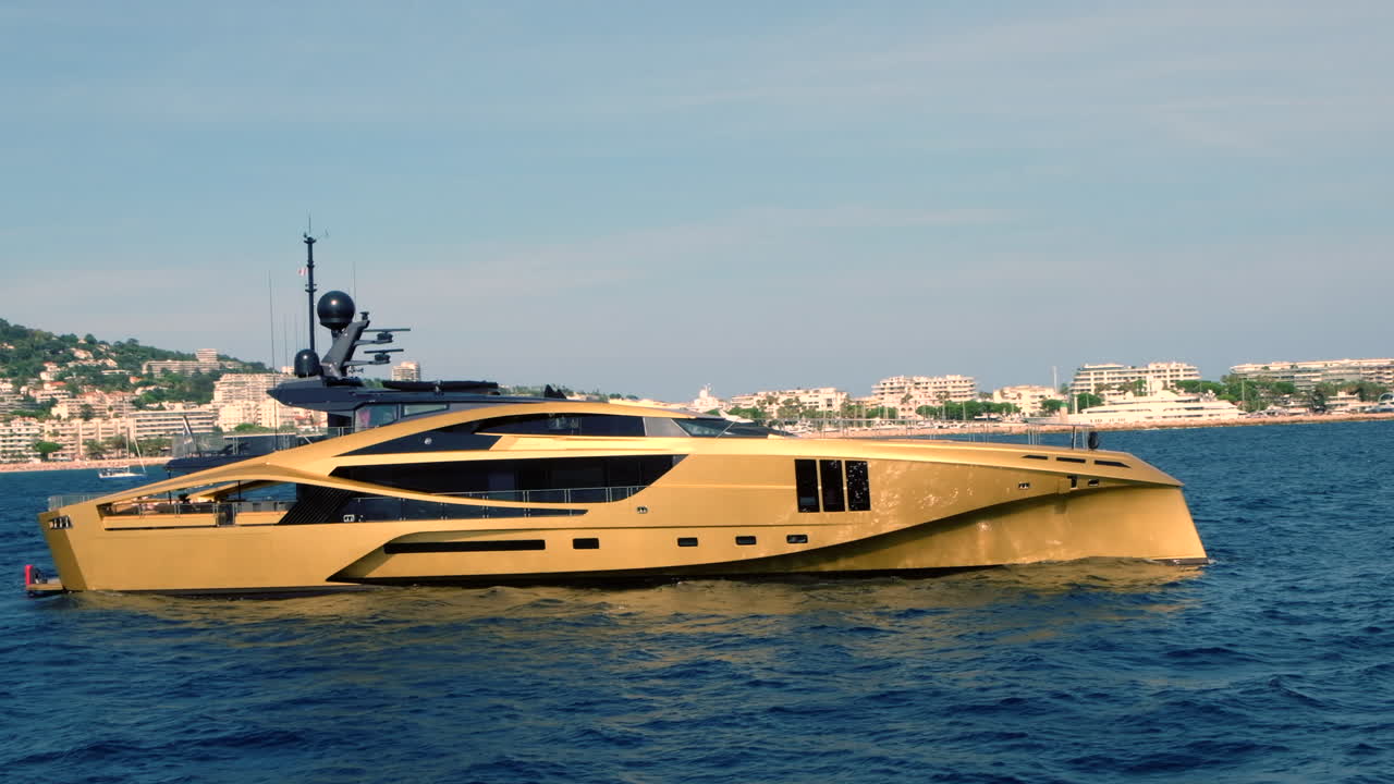 Lussuoso yacht dorato che naviga vicino alla costa di Cannes, Francia
