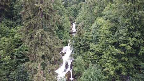 a bridge crossing the beautiful mountain waterfalls of obersee switzerland - wide