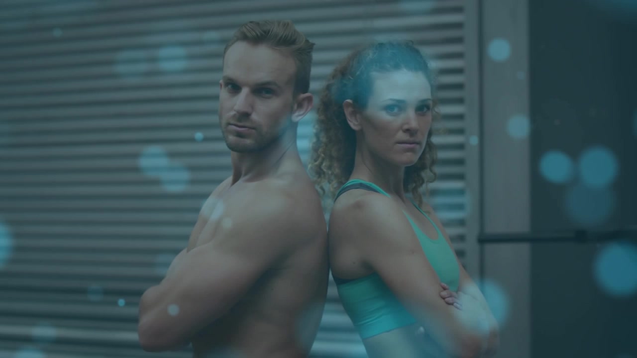 Uomo e donna in forma in piedi schiena contro schiena in palestra