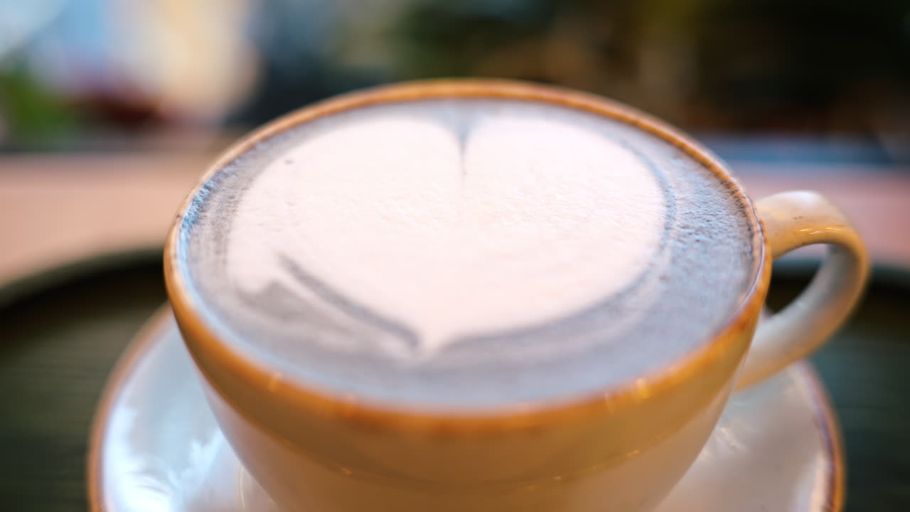 Blue matcha latte with heart shape foam in a ceramic mug