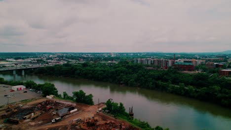 cumberland river in nashville, tn, showing riverside development, urban skyline, and active construction zone. america rising