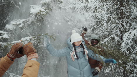 friends taking pictures in snowy winter forest