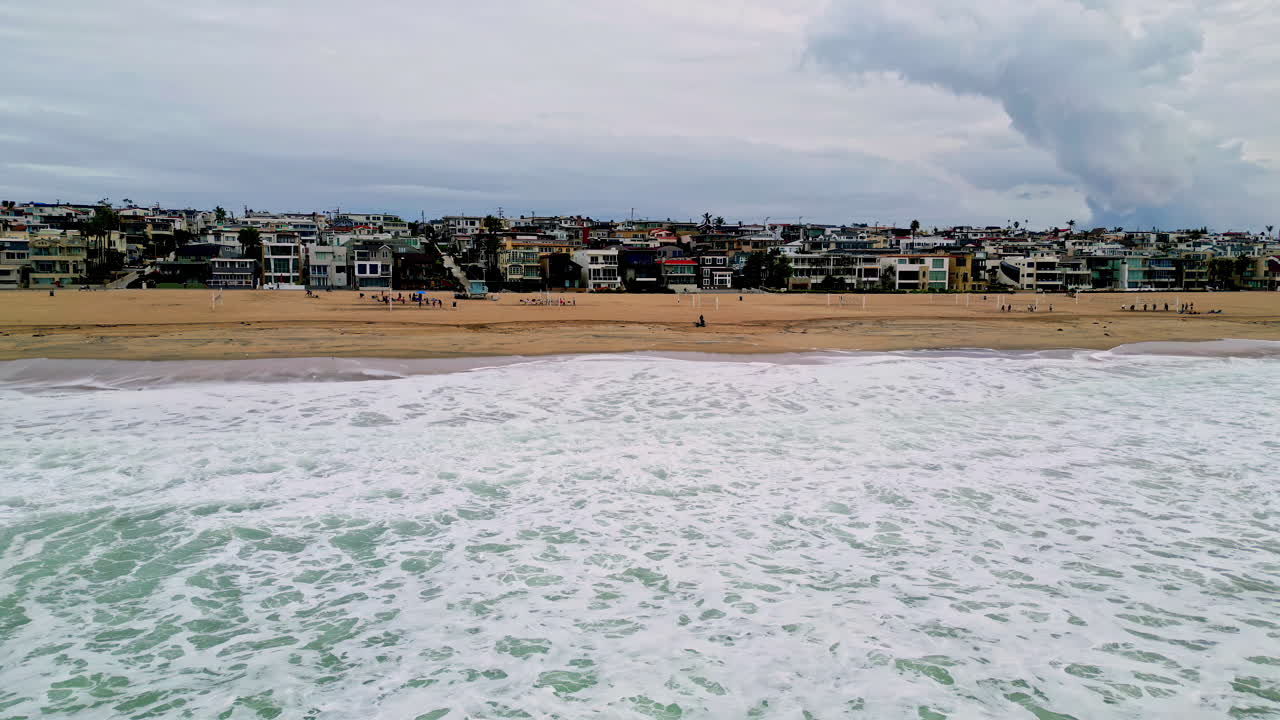 vista aérea de una aldea costera, un día tranquilo en la playa con un cielo sombrío en el fondo