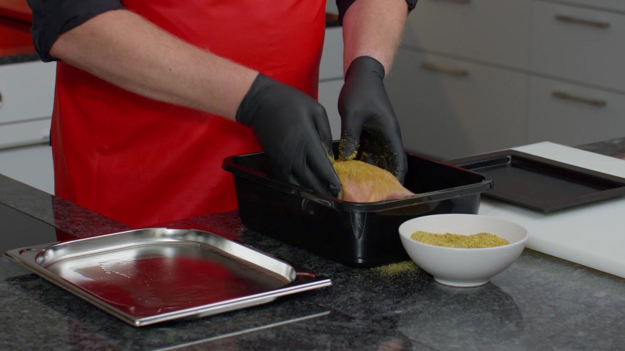 Primo piano, chef che condisce carne cruda in una cucina professionale. Ideale per catering, ristoranti, servizi di ristorazione, cucina, preparazione e concetti culinari