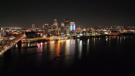 louisville, kentucky skyline at night with bridge in foreground with drone video circling