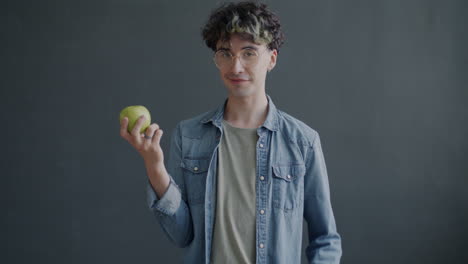young person holding an apple and a vegan sign