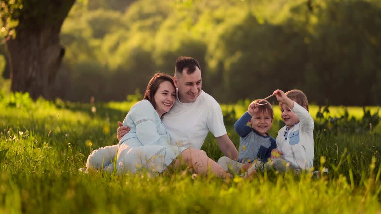 Família feliz em um piquenique no verão se divertindo conversando, rindo e comendo sorvete em câmera lenta.