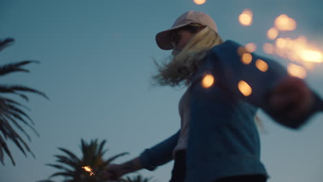 happy-teenage-girl-with-sparklers-dancing-on-beach-at-sunset-celebrating-new-years-eve-having-fun-independence-day-celebration-with-fireworks-enjoying-freedom