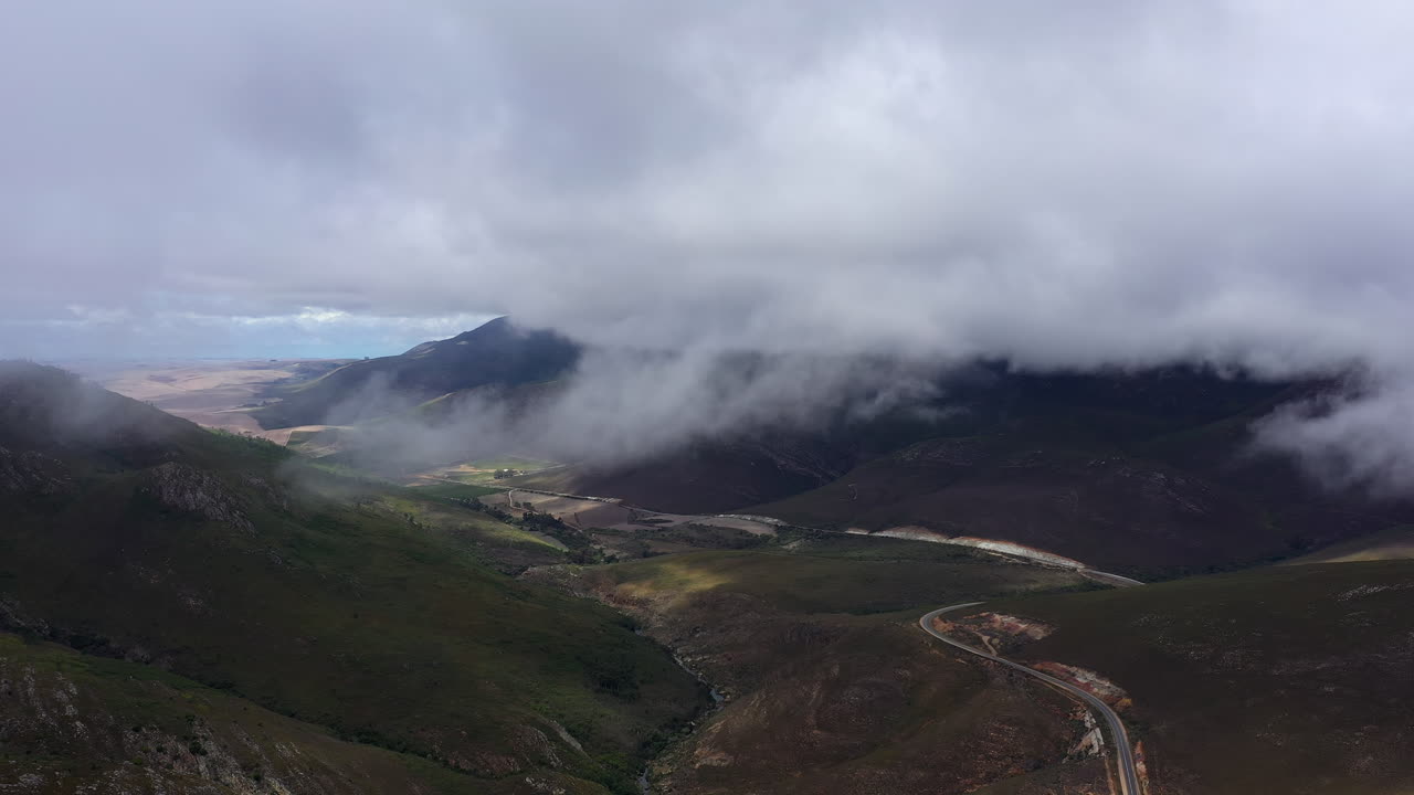 niebla sobre las montañas tiro aéreo carretera que pasa por un valle sudáfrica