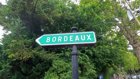 sign pointing towards bordeaux amidst lush greenery