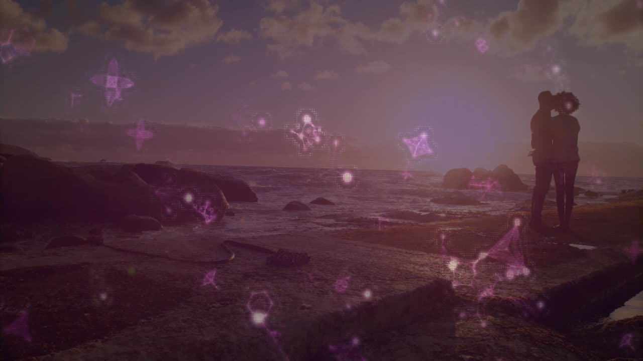 Silhouetted couple embracing by ocean with glowing pink animation overlay