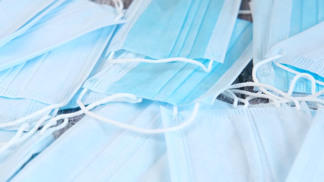 una pila de máscaras faciales desechables azules