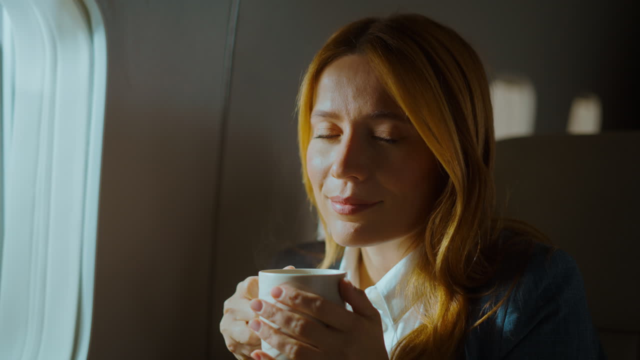 Woman Enjoying Coffee on an Airplane