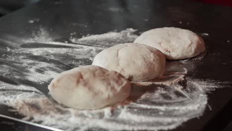 manos que forman la masa en la superficie de la harina