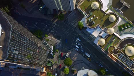 aerial top-down view of passing cars on eagle street intersection next to riverside dining complex, brisbane city australia