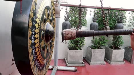 hitting the huge bell in a temple