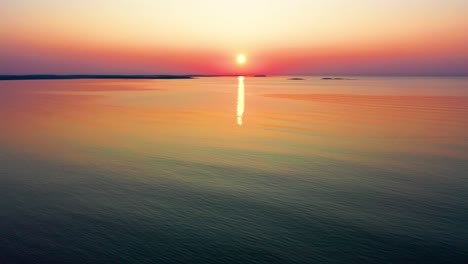 Aerial-Drone-View-of-Sunset-Colors-Reflecting-off-Ocean-Waves-Along-the-Coastline