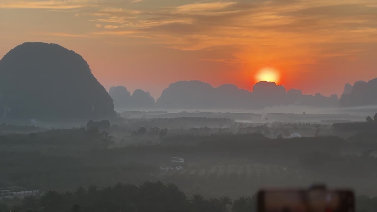 Bình minh rực rỡ trên những ngọn núi đá vôi và thung lũng sương mù tại Din Daeng Doi ở Krabi, Thái Lan với ánh nắng ấm áp, sương giăng nhẹ, địa hình phân lớp và phong cảnh nhiệt đới yên bình.