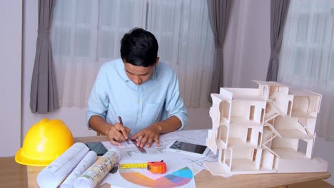 young asian architect man talking on phone and celebrating success