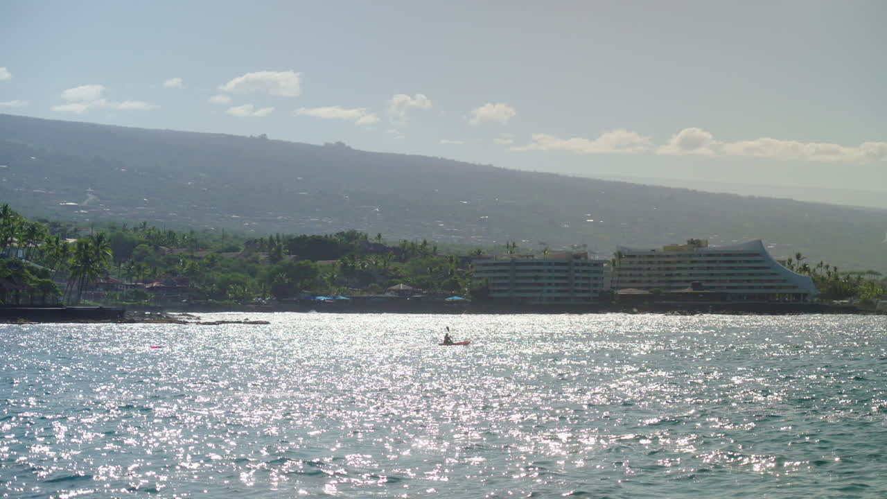 Kayaker che pagaia fuori dalla costa della baia di Kona alle Hawaii al tramonto, 4K rallentatore