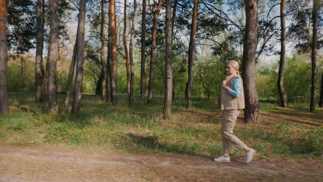 mujer caminando por un camino del bosque