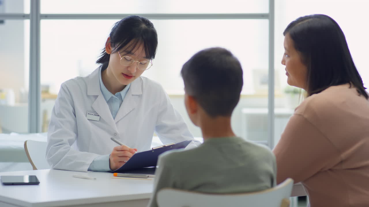 Asian Pediatrician Consulting Mother and Son
