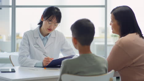 asian pediatrician consulting mother and son