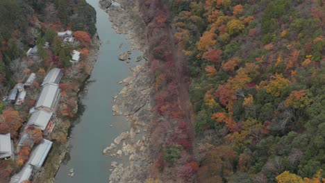 japanese temple in arashiyama mountain river with fall colors aerial view