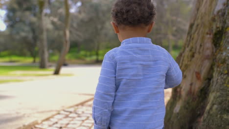 little boy running away from his father, turning back, smiling