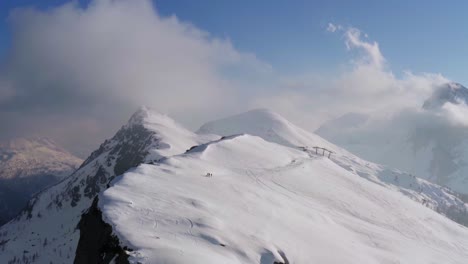 vista aérea épica de la expedición de excursionistas escalando laderas nevadas de una montaña en invierno.