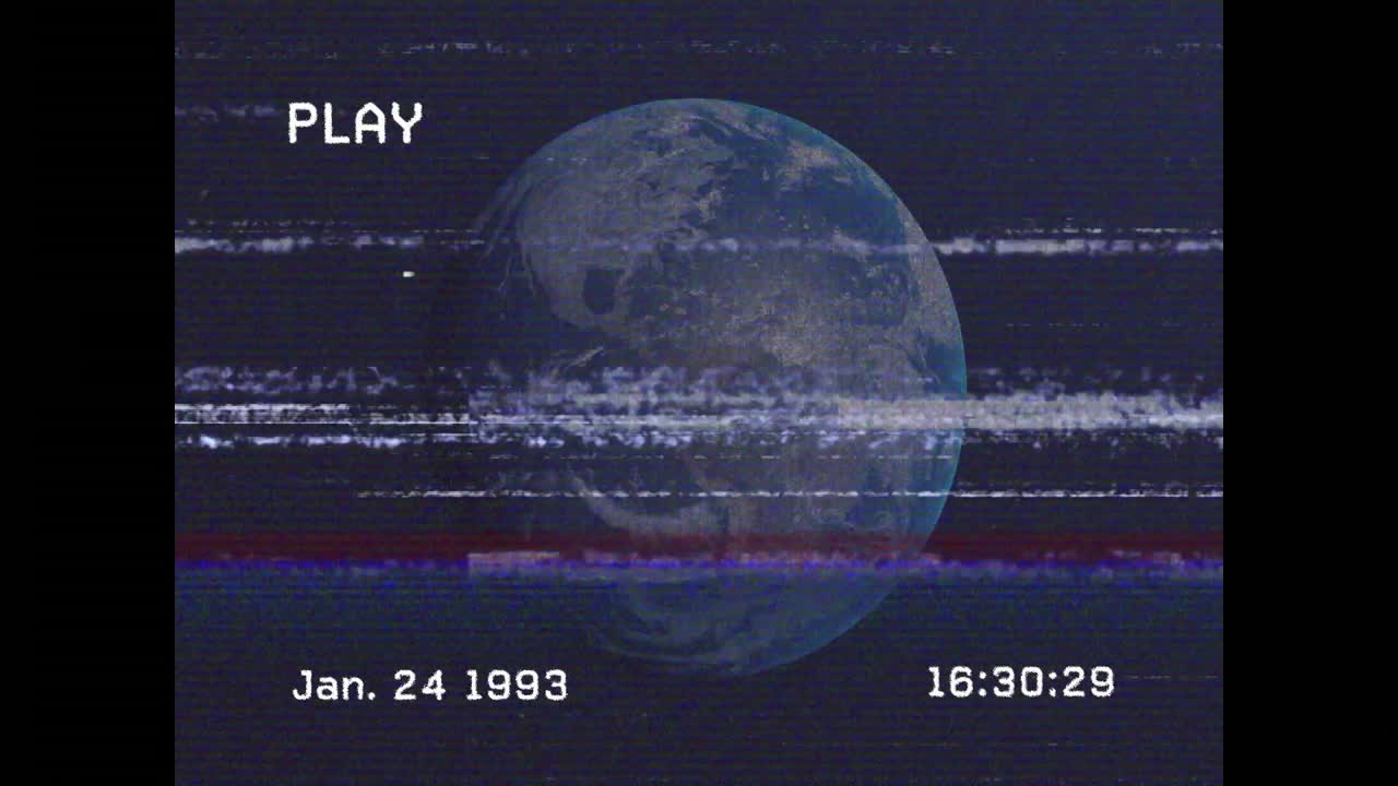 Indikátor PLAY, spouštějící aktualizaci časové značky, a Země rotující s glitch efekty simulujícími VHS