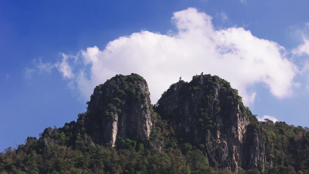 Bầu trời xanh và nhiều mây, đỉnh núi với chùa Phật giáo ở Lampang