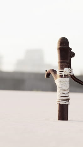 a rusty old hand pump standing in the sand