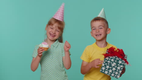 niños felices muchacho niña hermanos amigos celebrando cumpleaños soplando velas en el pastel haciendo un deseo
