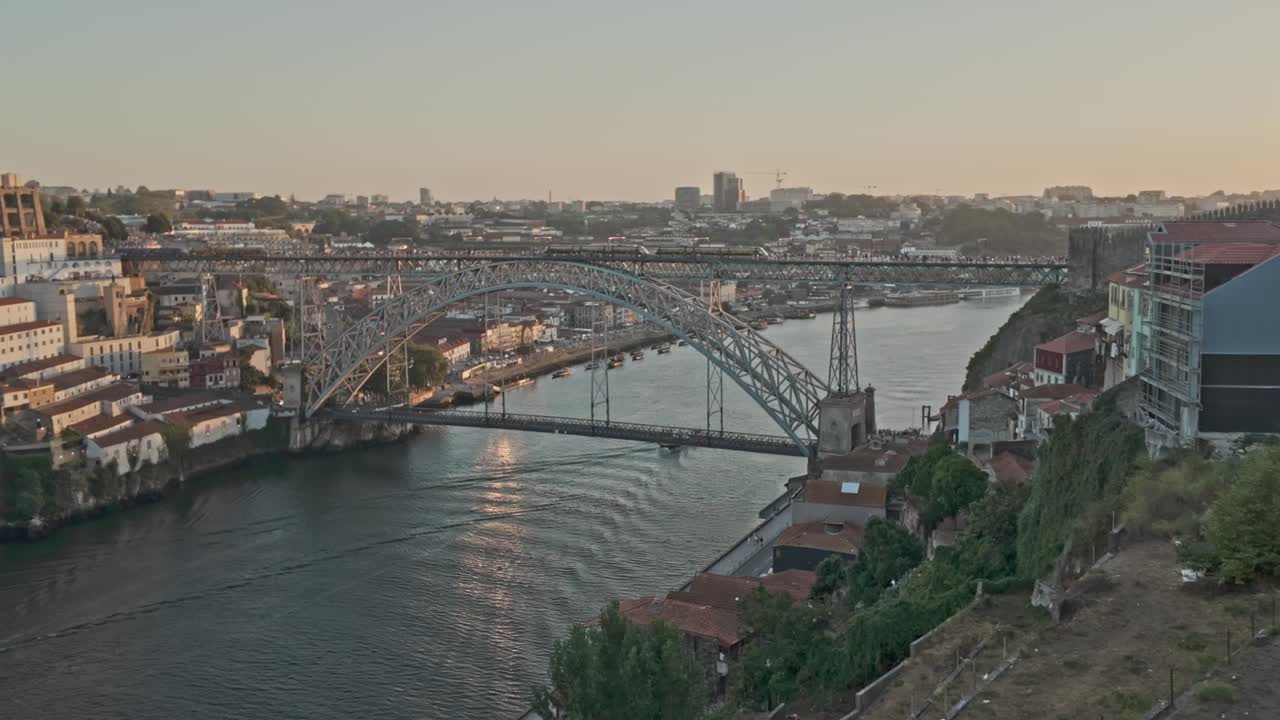 도로 강을 가로지르는 포르토의 루이스 i 다리의 해가 지는 모습과 도시의 스카이 라인 배경