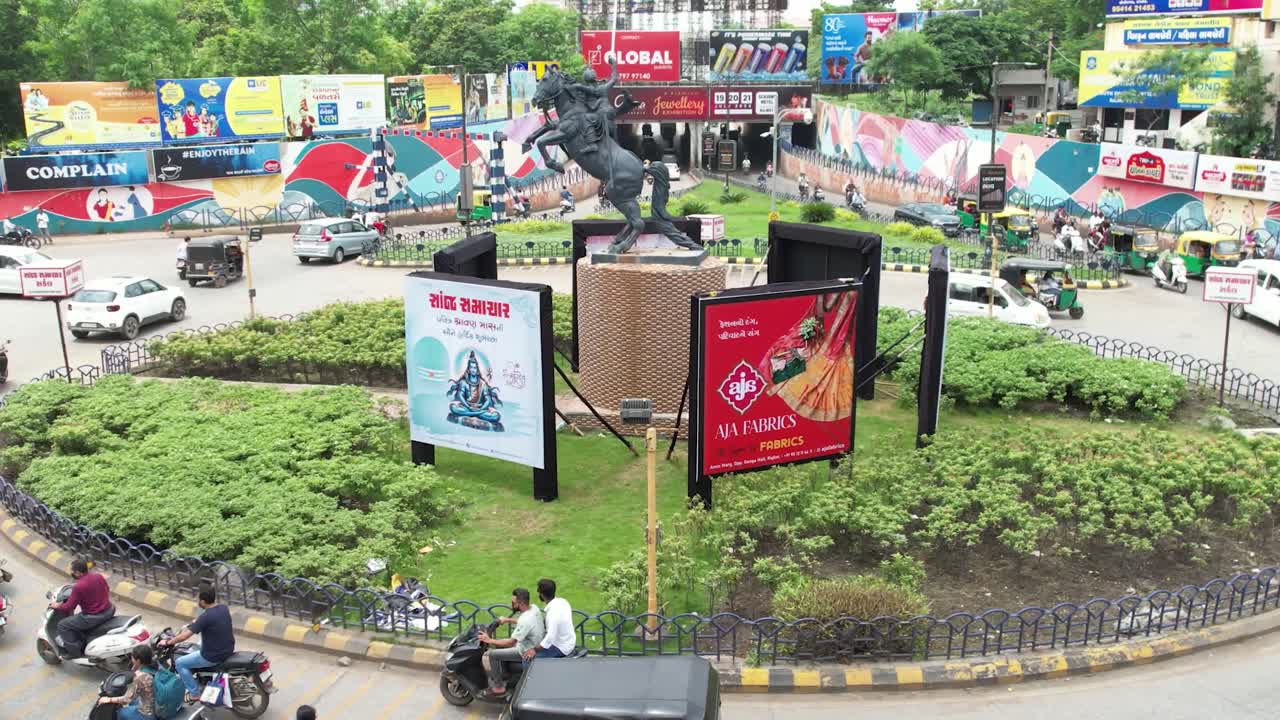 A lot of vehicles such as bikes, motorcycles, four wheel buses are passing through the circle.