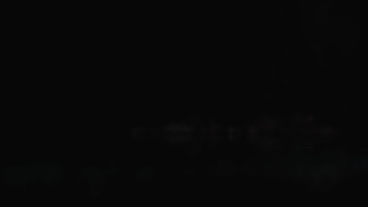 los pimientos cortados en rodajas rojas están cayendo sobre el vidrio con salpicaduras de agua en cámara lenta sobre un fondo oscuro