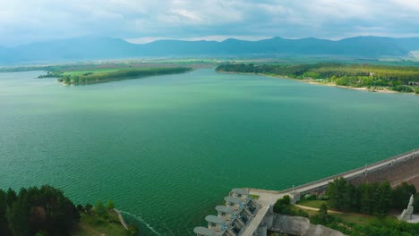 Flying-over-the-huge-Koprinka-dam-with-blue-clouds-over-it-during-a-summer-day