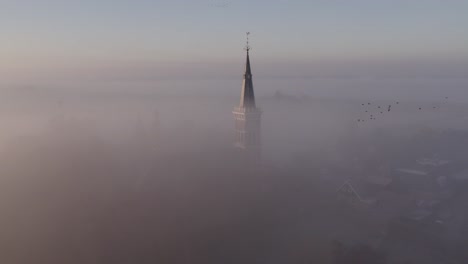 chiesa di cornwerder nella provincia di friesland in una densa nebbia mattutina, aerea