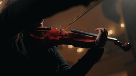 female violinist is playing in symphonic orchestra closeup view of violin in woman hands