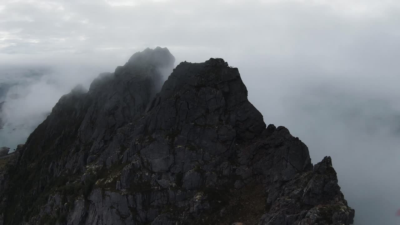 Volare lungo la cresta di una montagna, poi fare cliff diving in Norvegia con vista sulla costa, sull'oceano e su un ponte che parte dalla cima di una montagna, al rallentatore.