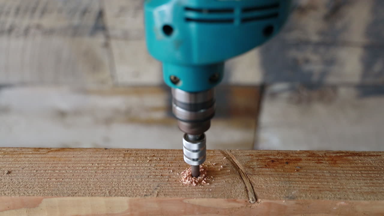 A drill bit drilling a hole into a piece of wood