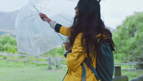 Rain,-hiking-and-woman-with-umbrella-in-nature