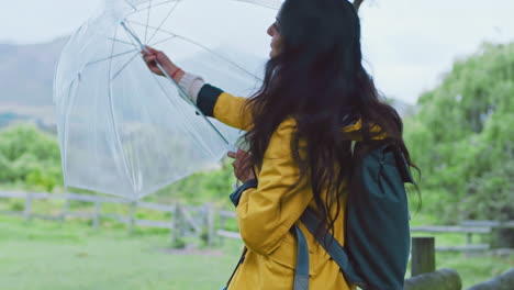 lluvia, senderismo y mujer con paraguas en la naturaleza