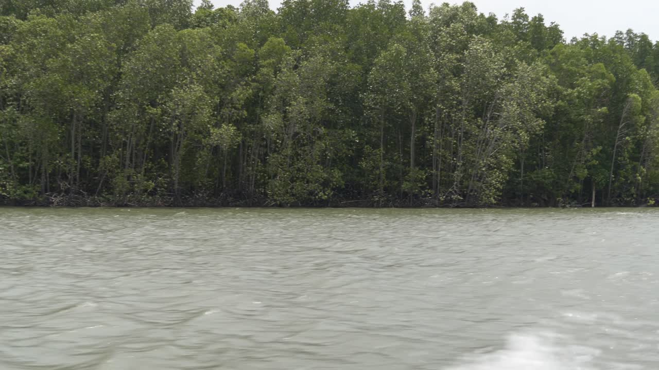 Small tourist boat navigating the calm waters in Phang Nga Bay, Thailand, heading to James Bond Island