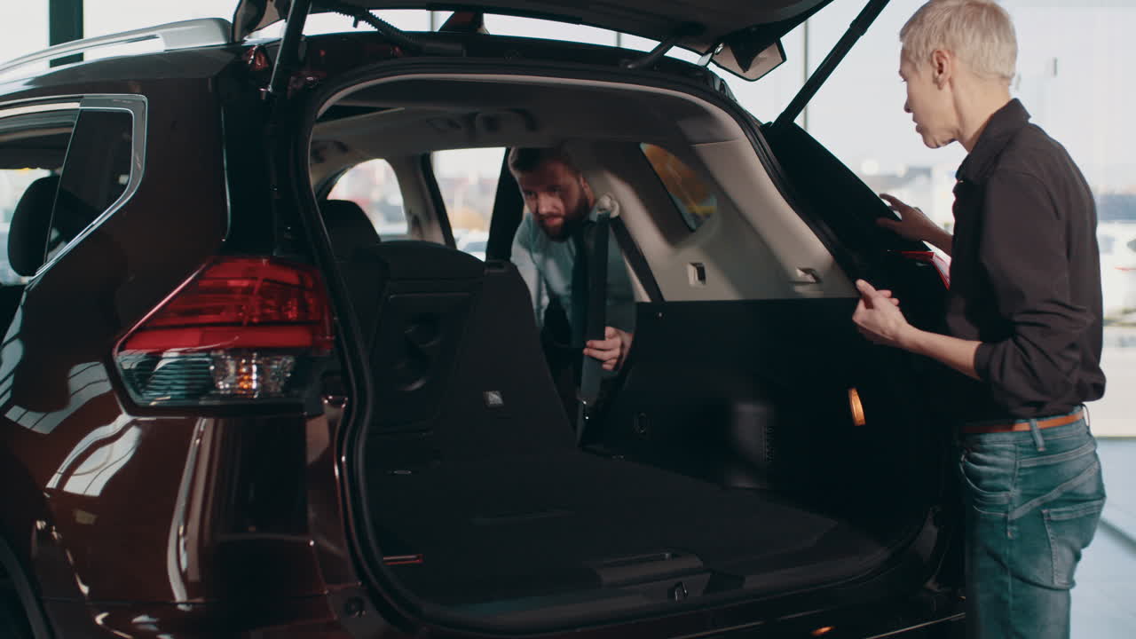 새로운 suv의 빈 트크를 바라보는 여자