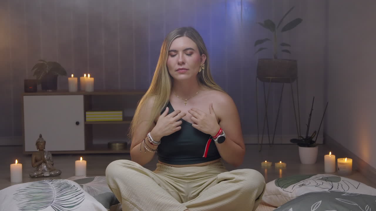 Mujer rubia medita, se da golpecitos en el pecho, serena, movimiento lento