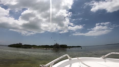 Boat-Floating-in-front-of-Bird-Island-in-Holbox,-Mexico